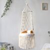 Cama de rede suspensa em macramé branco com gato deitado