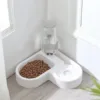 Comedouro e bebedouro em forma de coração, com ração e água, num canto de casa