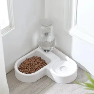 Comedouro e bebedouro em forma de coração, com ração e água, num canto de casa